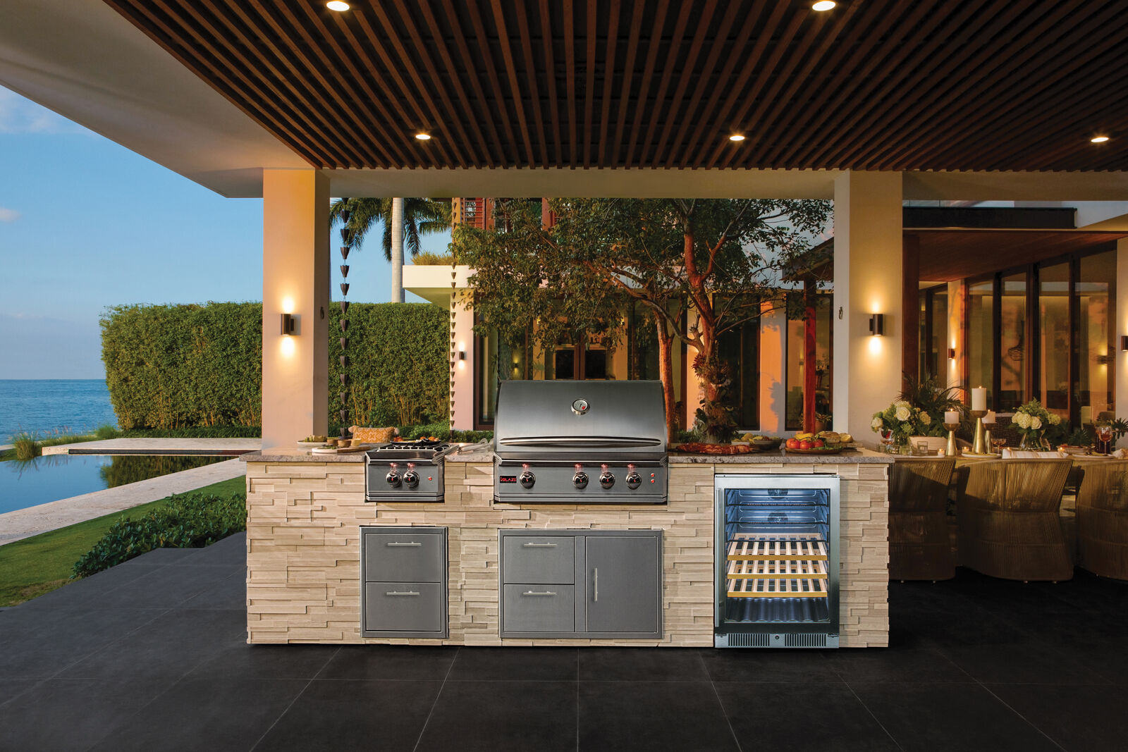 Outdoor kitchen with glass-door refrigerator and grill